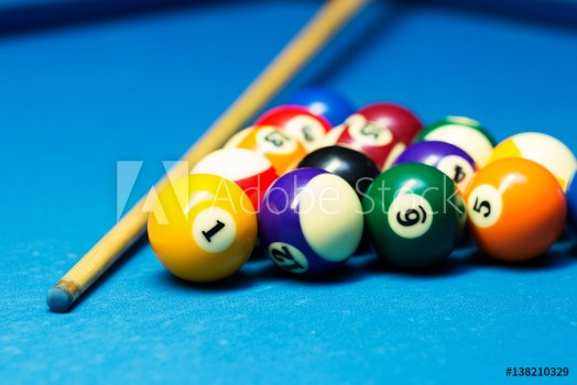 Picture of Pool billiard balls and cue on the blue cloth table